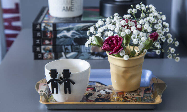 No projeto da arquiteta Pati Cillo, ao lado da cama, a mesa lateral ganhou uma bandeja onde está a xícara customizada com os bonequinhos que celebram a união do casal. Colorida, a segunda xícara se transformou num simpático vasinho de flores | Foto: Luis Gomes